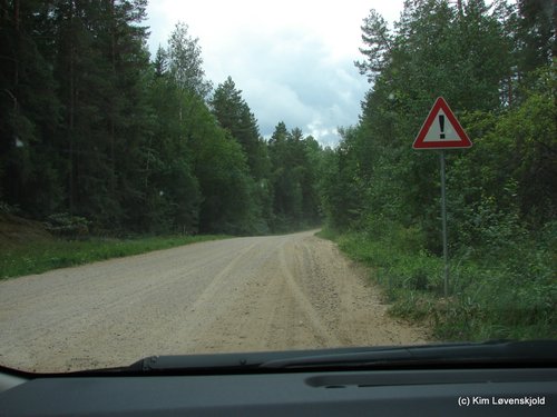 Gravel road in Latvia and a ! sign